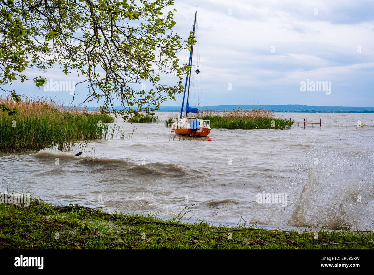Un voilier seul attendant sur le lac Balaton pour une tempête à venir à passer. Banque D'Images