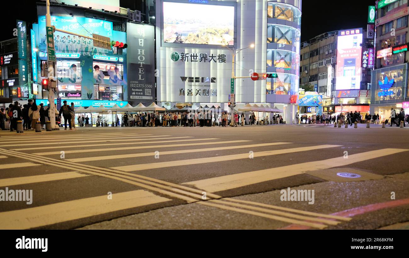 Scène de nuit, passages en croix, piétons et panneaux publicitaires éclairés à l'angle de Chengdu Road et Hanzhong Street; Taipei, Taiwan Banque D'Images