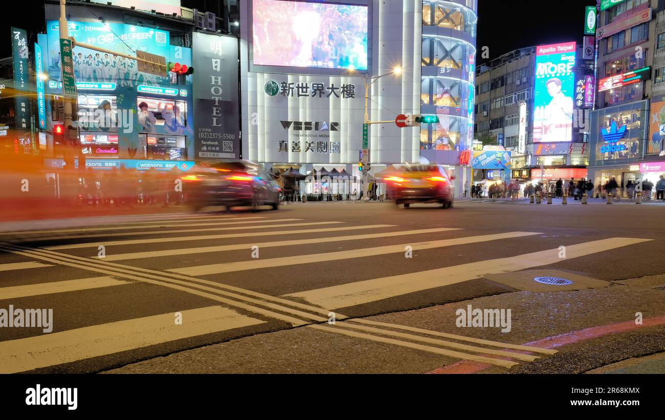 Scène nocturne, circulation, piétons, et allumé des panneaux publicitaires et d'affaires au coin de Chengdu Road et Hanzhong Street; Taipei, Taiwan. Banque D'Images