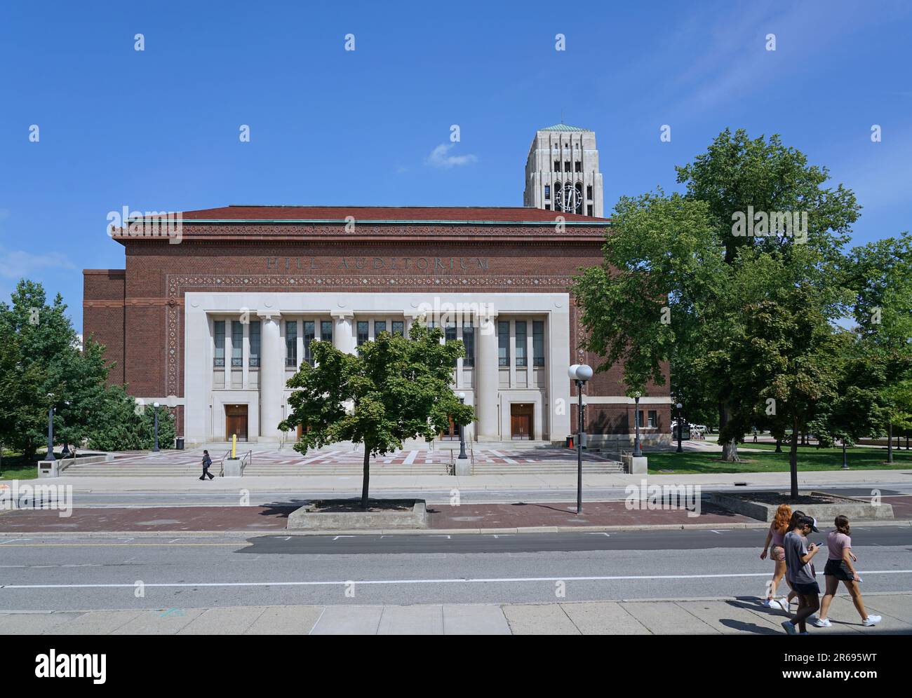 Des étudiants qui marchent sur le campus de l'Université du Michigan, Ann Arbor, avec un grand auditorium et une tour d'horloge Banque D'Images