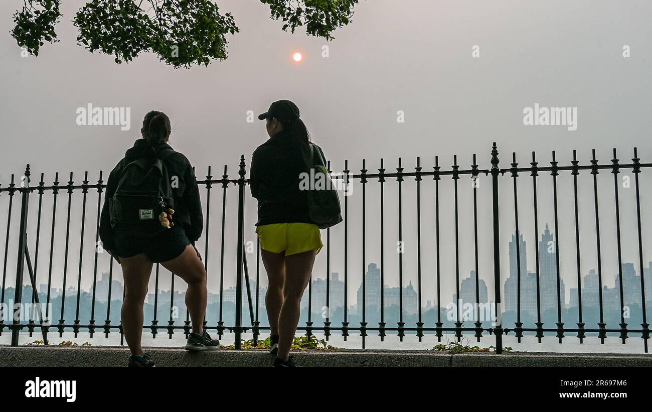 New York, États-Unis. 7th juin 2023. Un brouillard dense causé par la fumée des feux de forêt canadiens bloque le soleil et la vue de Manhattan au réservoir de Central Park en milieu d'après-midi. La qualité de l'air dans la ville de New York est à son pire niveau jamais enregistré, ce qui a provoqué une crise d'urgence qui a inclus la fermeture d'écoles et l'annulation de la plupart des activités de plein air. Credit: Enrique Shore/Alay Live News Banque D'Images
