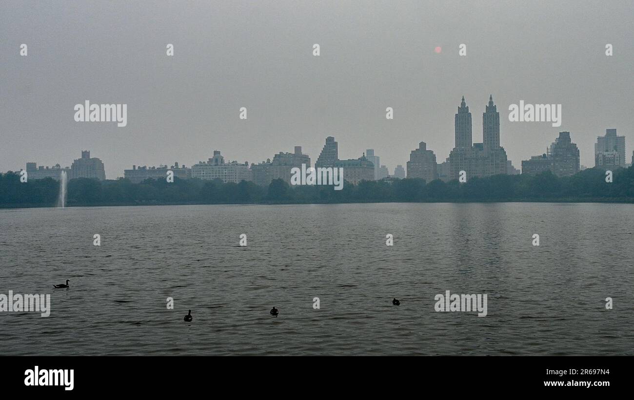 New York, États-Unis. 7th juin 2023. Un brouillard dense causé par la fumée des feux de forêt canadiens bloque le soleil et la vue de Manhattan au réservoir de Central Park en milieu d'après-midi. La qualité de l'air dans la ville de New York est à son pire niveau jamais enregistré, ce qui a provoqué une crise d'urgence qui a inclus la fermeture d'écoles et l'annulation de la plupart des activités de plein air. Credit: Enrique Shore/Alay Live News Banque D'Images
