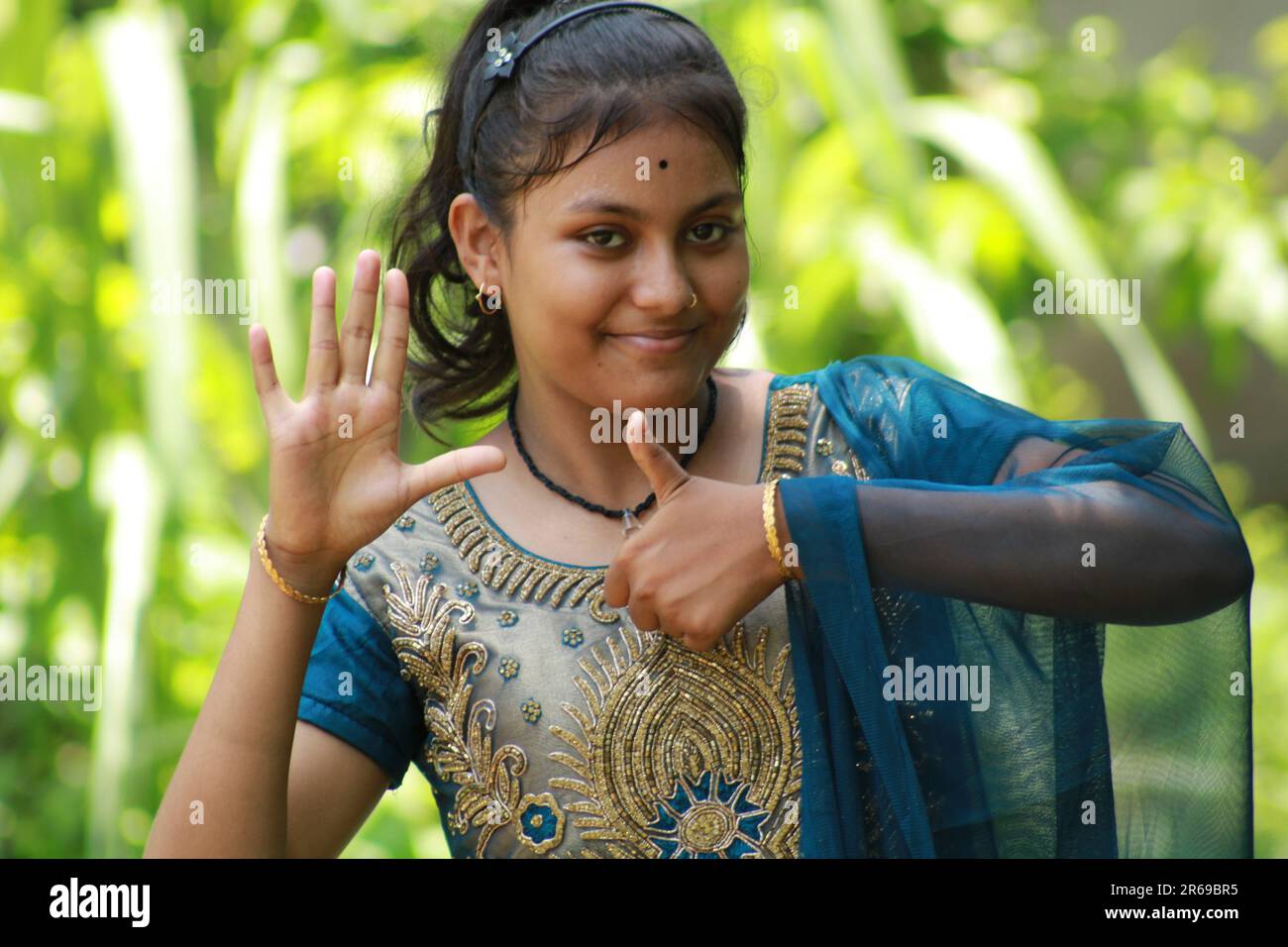 Indian Teenage Girl montrant et pointant avec le doigt numéro six tout en souriant confiant et heureux. Banque D'Images