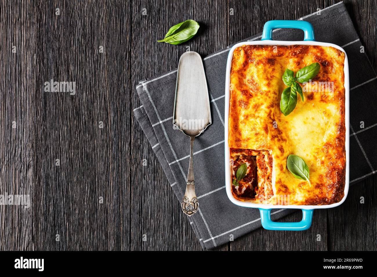 lasagnes al forno, lasagnes de bœuf italien avec sauce ragu classique, nouilles de pâtes et ricotta dans un plat de cuisson sur table en bois sombre, horizontal Banque D'Images