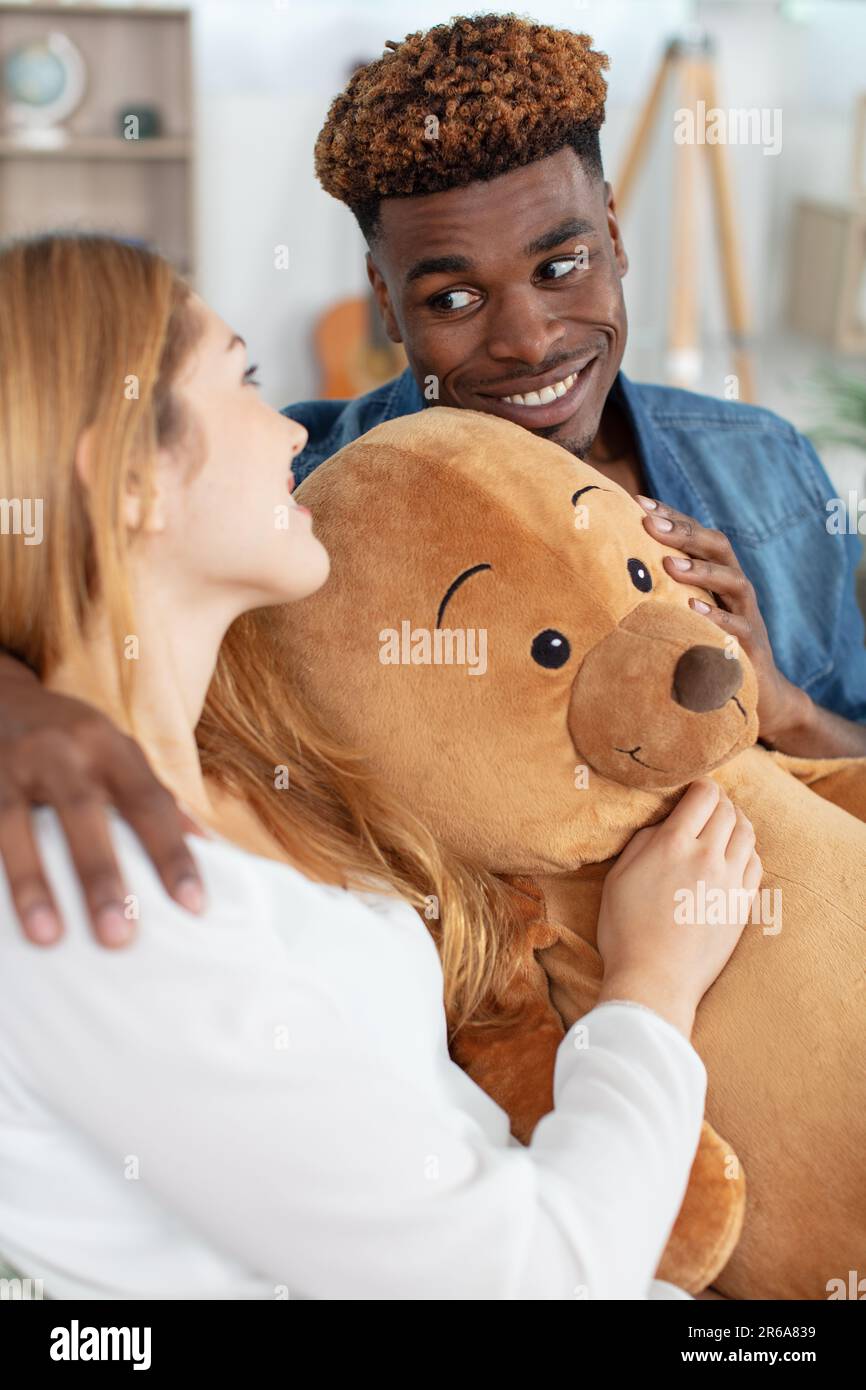 petit ami amoureux donnant l'ours en peluche à une petite amie