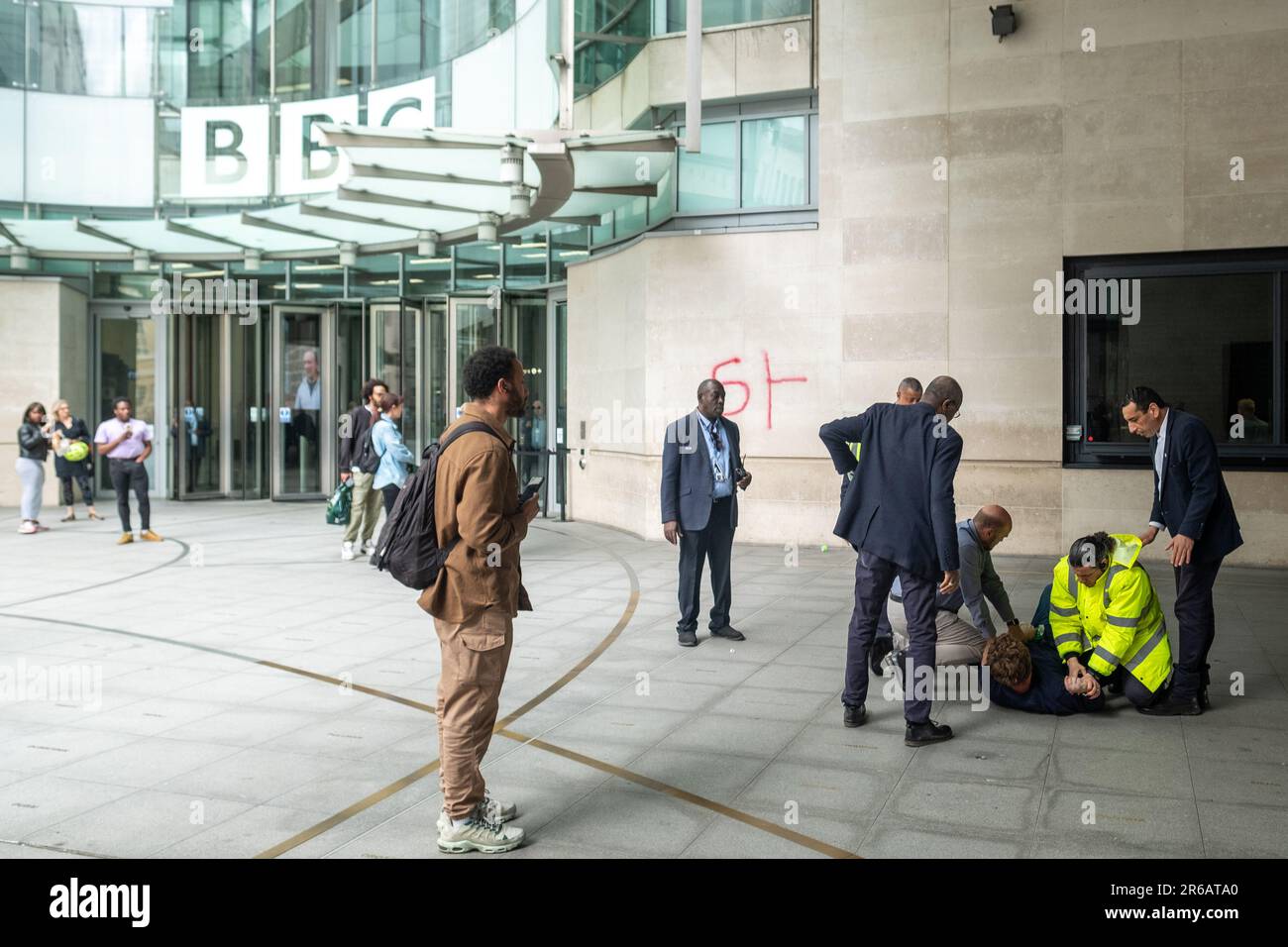 Londres- 23 mai 2023: Un manifestant anti BBC tente de vaporiser quelque chose sur BBC Broadcasting House et est attaqué par la sécurité. Banque D'Images