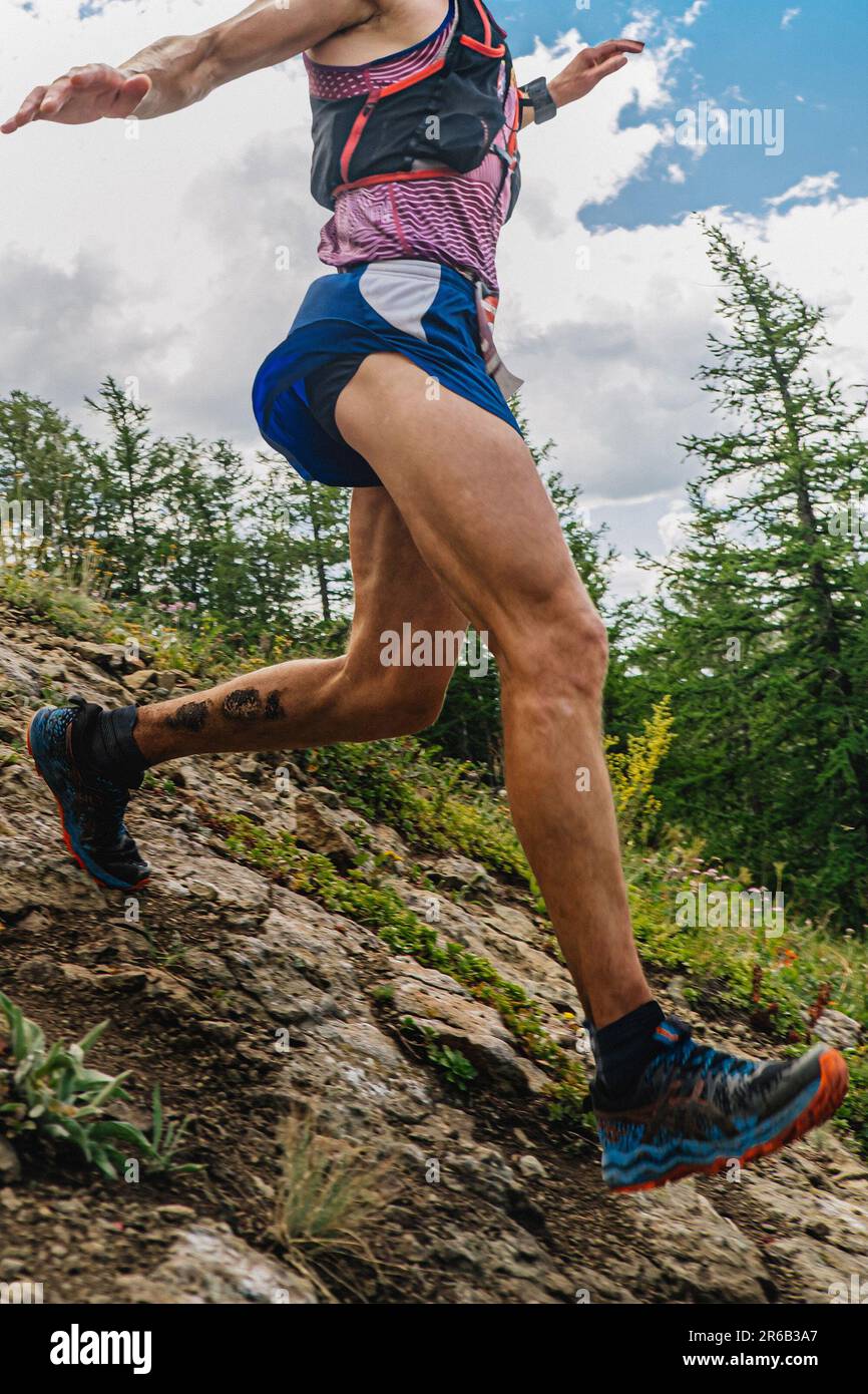 coureur de gros plan qui s'exécute sur une pente raide de montagne, course de marathon d'été Banque D'Images coureur de gros plan qui s'exécute sur une pente raide de montagne, course de marathon d'été Banque D'Images