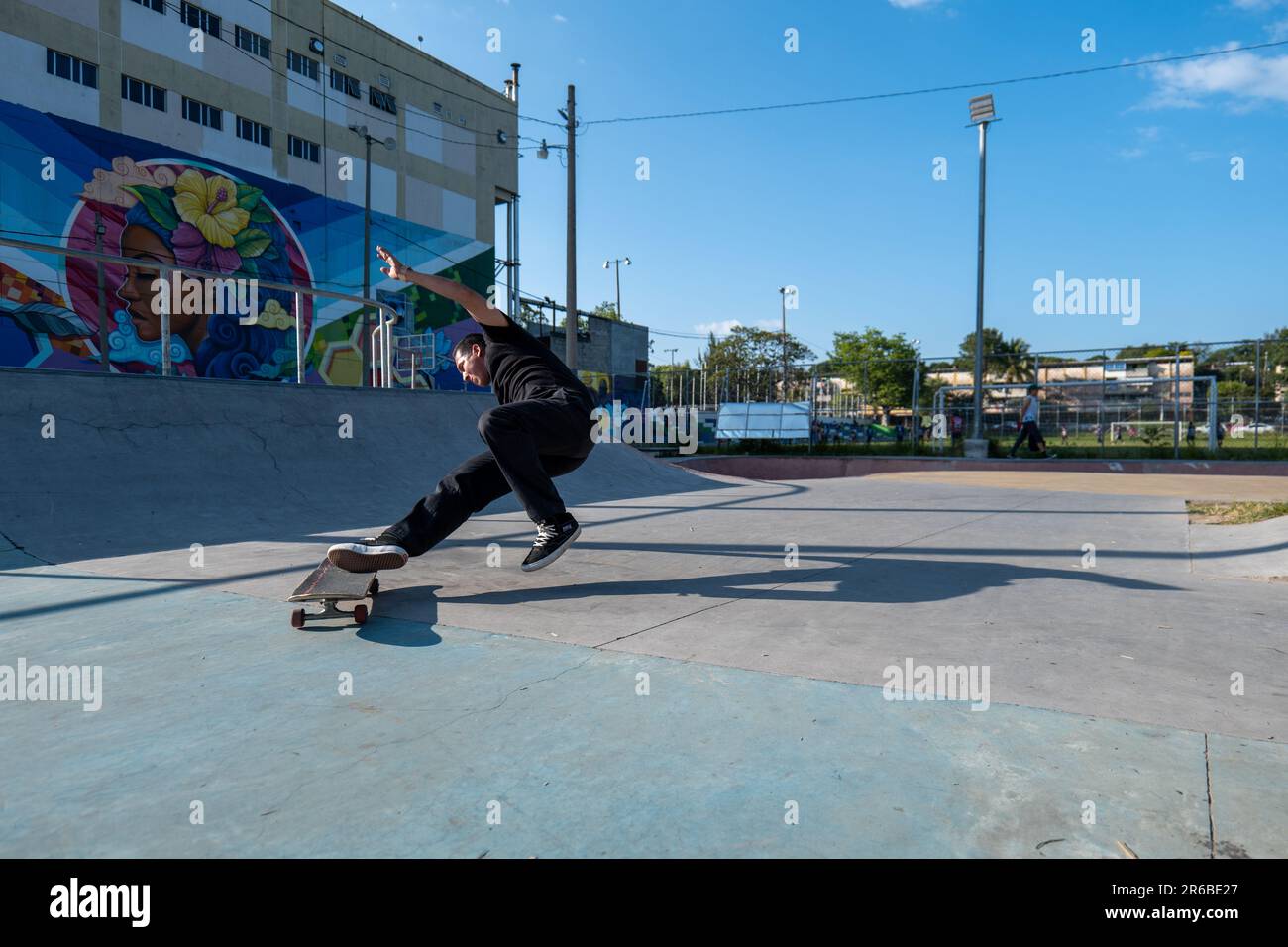 San Salvador, San Salvador, El Salvador - 11 novembre 2022: Le jeune homme brun tombe sur le sol après avoir essayé un tour de skateboard dans un parc de skate Banque D'Images