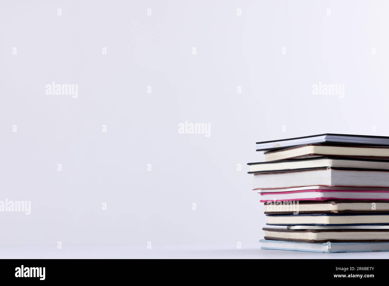 Gros plan de la pile de livres et de carnets avec un espace de copie sur fond blanc. Concept de lecture, d'apprentissage, d'école et d'éducation. Banque D'Images