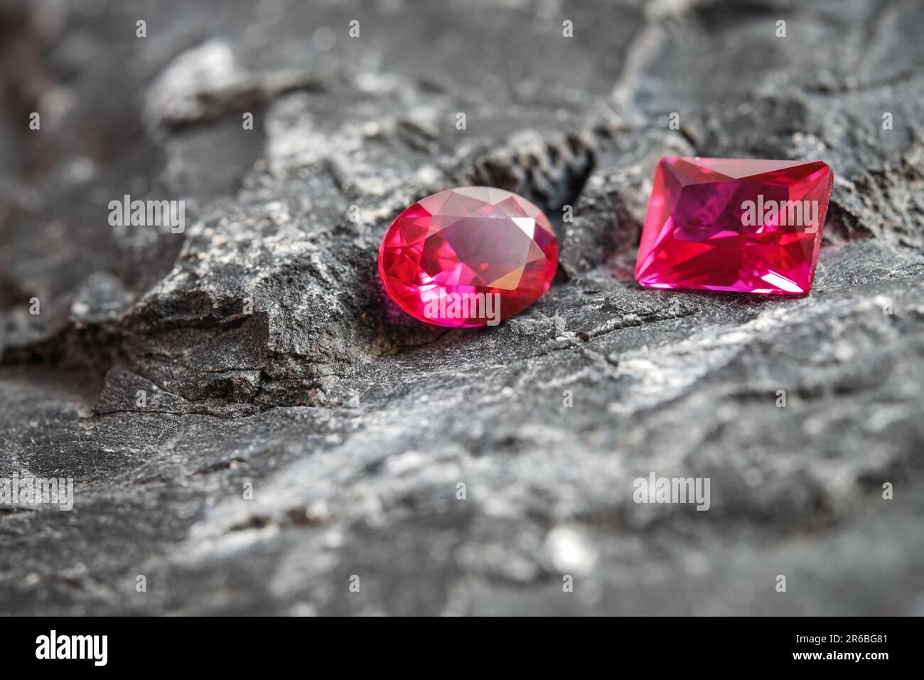 Les pierres gemmes de saphir rose scintillant sur une surface rocheuse robuste Banque D'Images