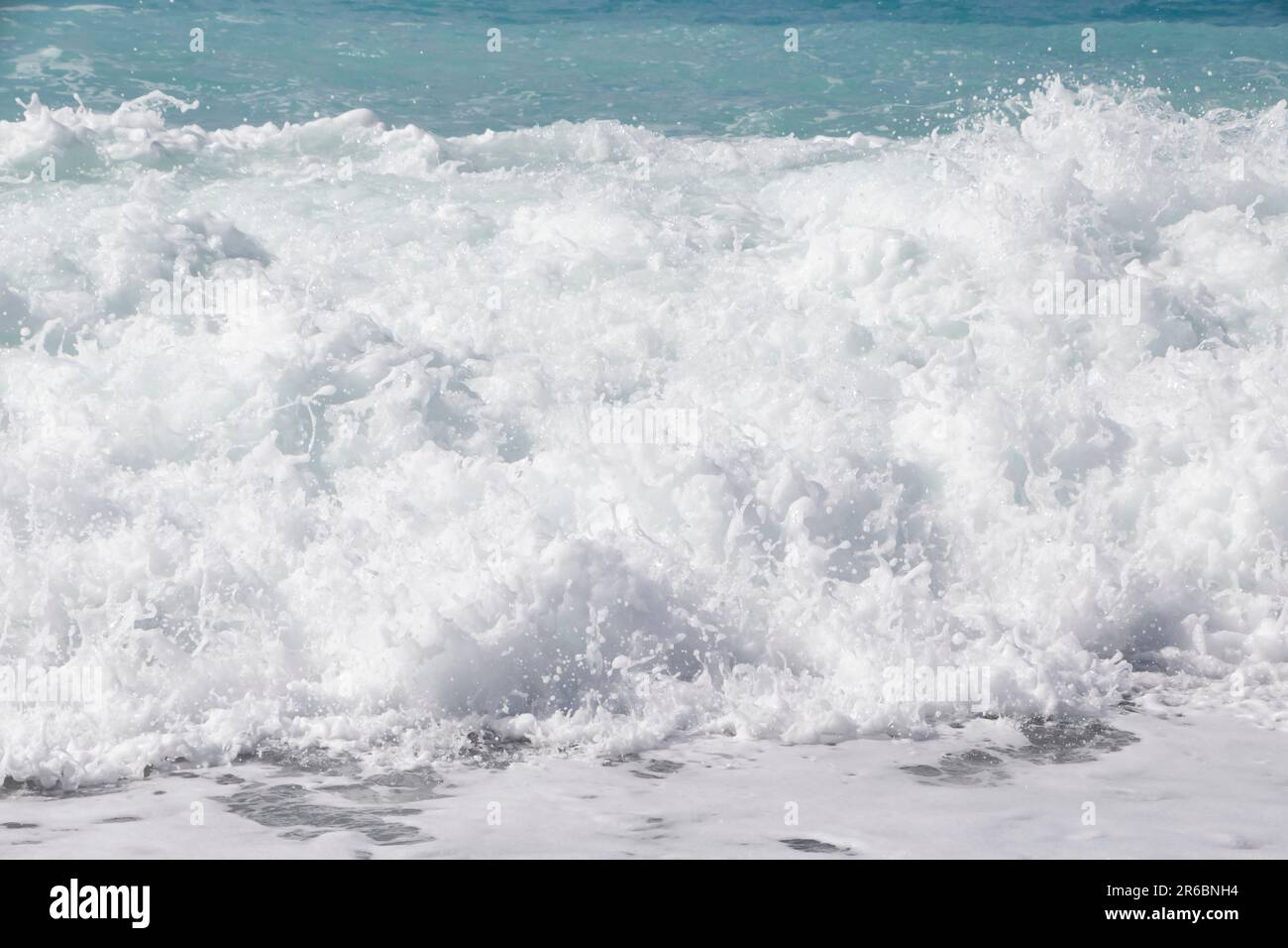 Gros plan sur la plage de Nice, une vague de mousse blanche Banque D'Images