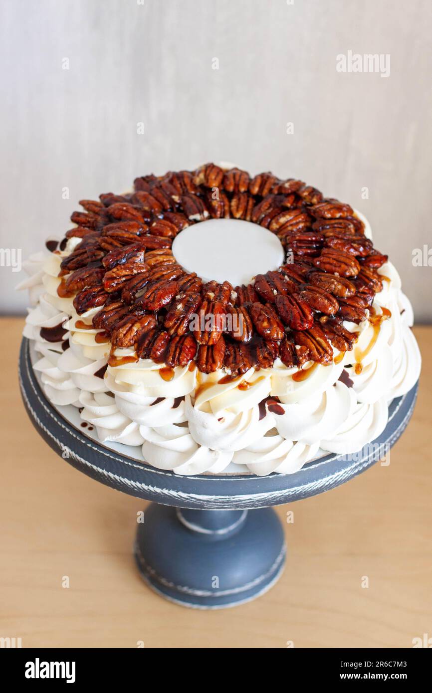 Délicieux gâteau Pavlova avec pacanes, sauce au chocolat, sirop d'érable et assiette de fondant pour le texte Banque D'Images