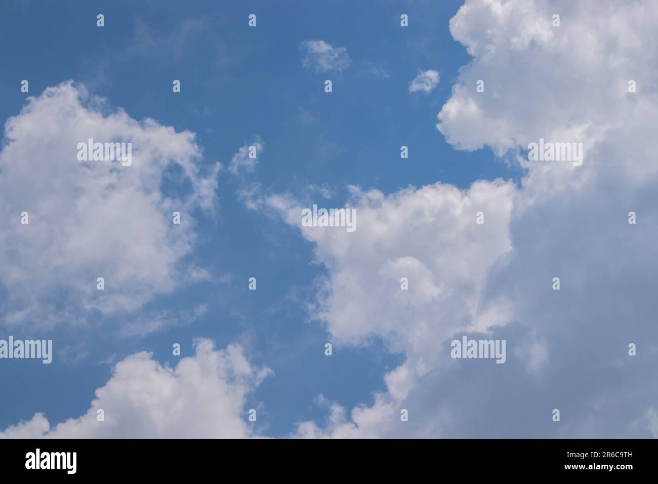 Un beau ciel vibrant de nuages blancs moelleux et une atmosphère lumineuse azur offrent un paysage idyllique d'été dans l'environnement en plein air. Banque D'Images