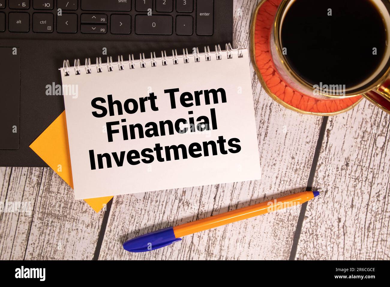 Concept d'entreprise. Sur une surface blanche, des cubes, des dollars, un stylo et un bloc-notes avec l'inscription - investissements financiers à court terme Banque D'Images
