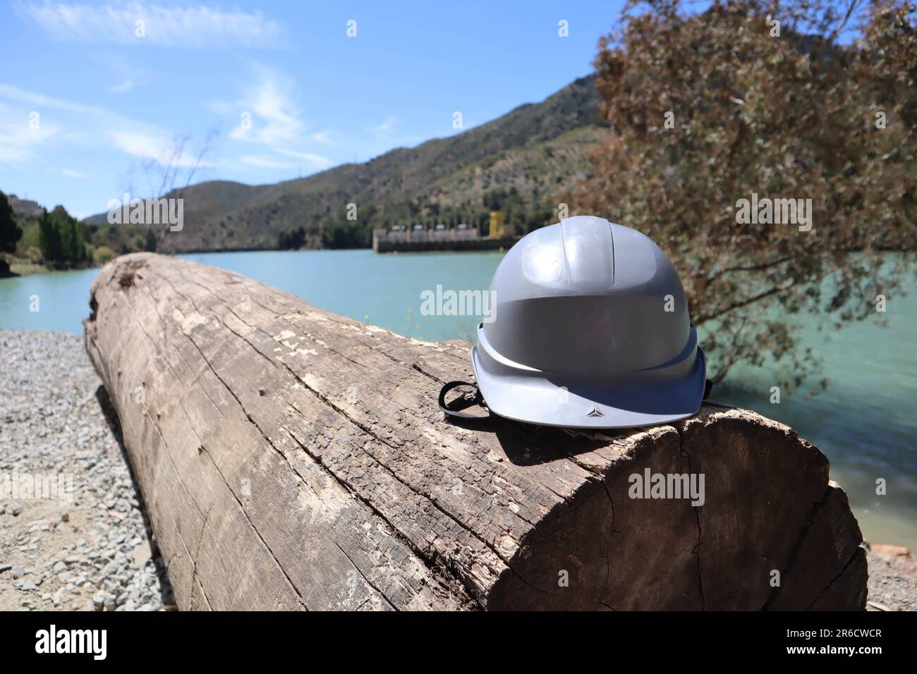 Casque gris sur une bûche près d'un paysage fluvial, centrale hydroélectrique, réservoir Tajo de la Encantada, caminito del rey, Malaga, Espagne Banque D'Images