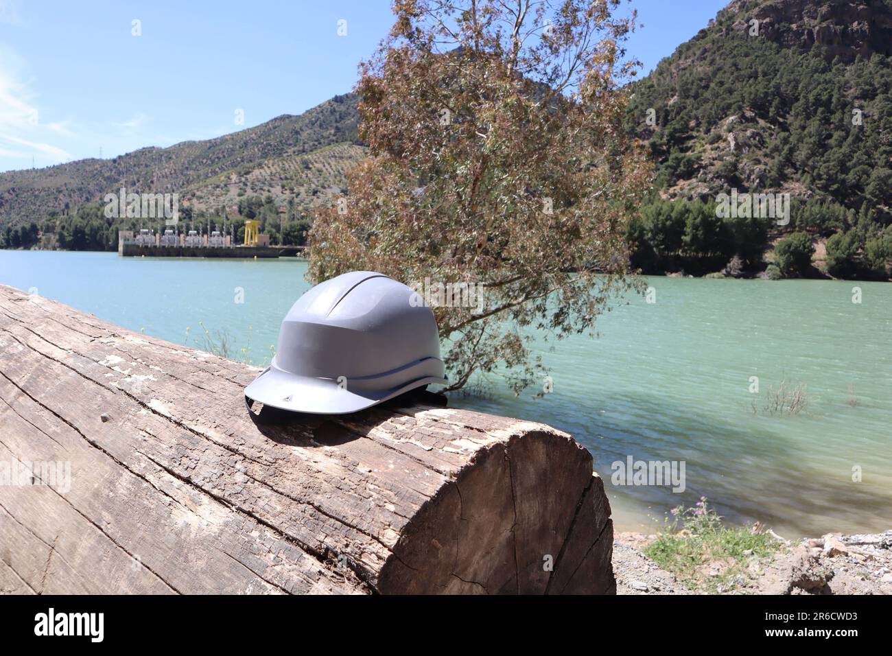 Casque gris sur une bûche près d'un paysage fluvial, centrale hydroélectrique, réservoir Tajo de la Encantada, caminito del rey, Malaga, Espagne Banque D'Images