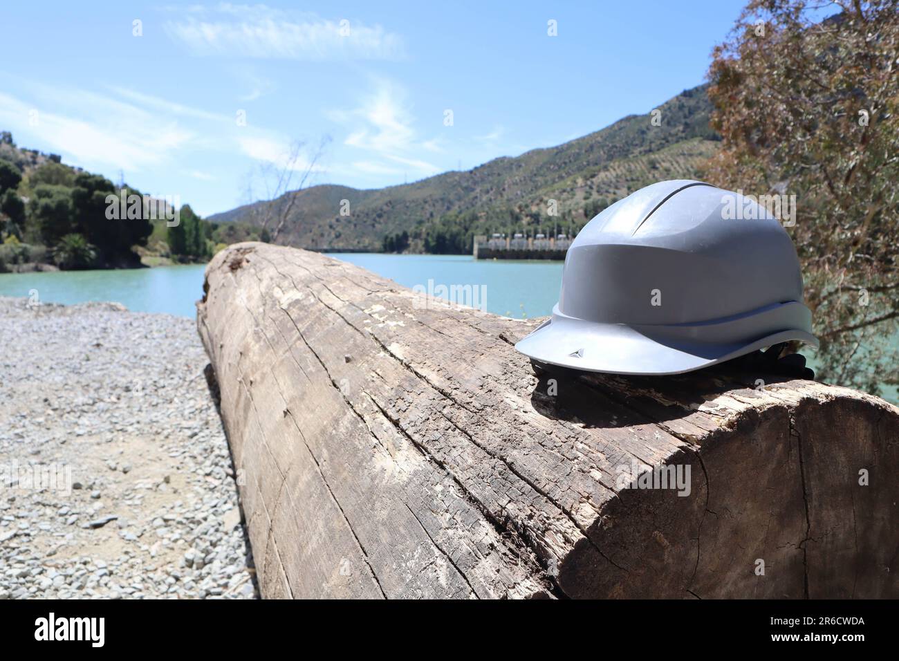 Casque gris sur une bûche près d'un paysage fluvial, centrale hydroélectrique, réservoir Tajo de la Encantada, caminito del rey, Malaga, Espagne Banque D'Images