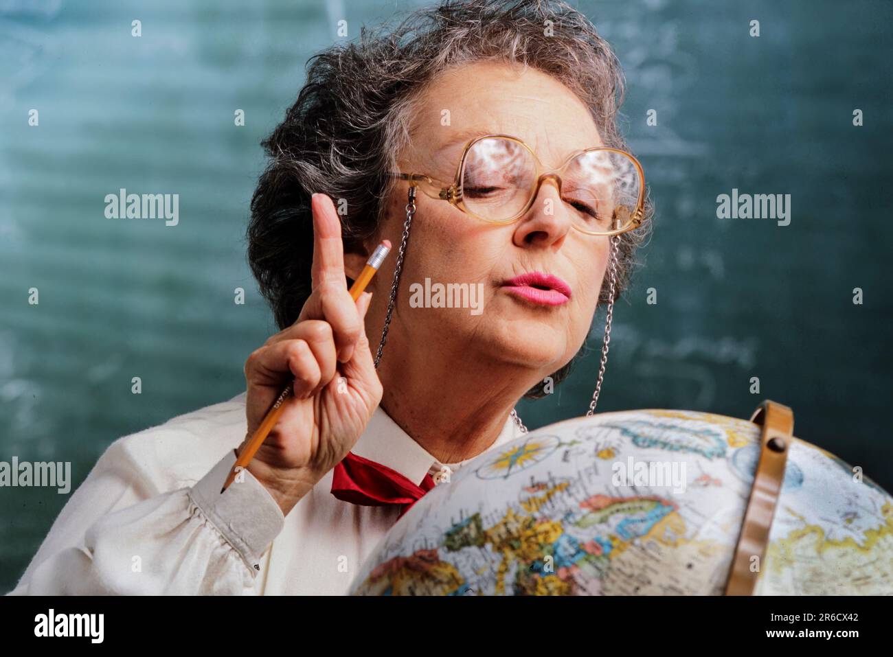 Un professeur de géographie fait un point en regardant un globe Banque D'Images