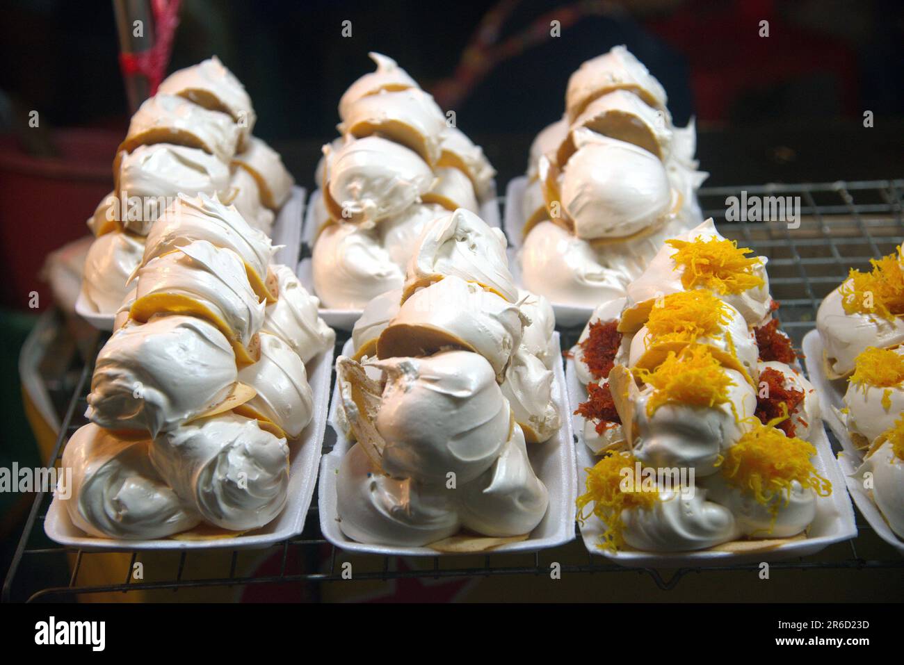 Kanom Bueng ou crêpes thaïlandaises avec diverses garnitures telles que crème anglaise, crème blanche sucrée fils de jaune d'œuf ou crevettes hachées salées sur la poêle. Banque D'Images