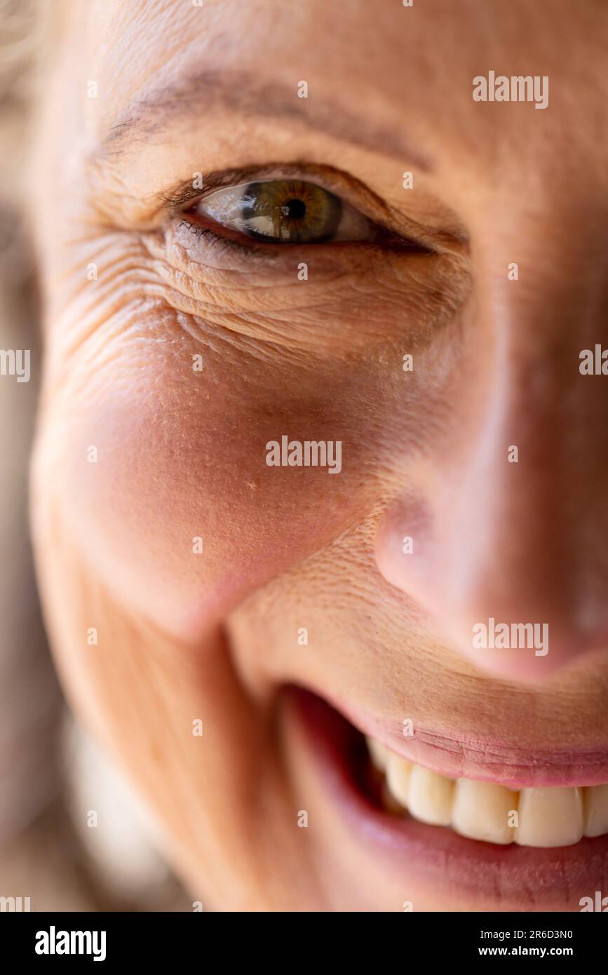Portrait en gros plan d'une femme caucasienne âgée souriante avec un œil marron regardant l'appareil photo Banque D'Images