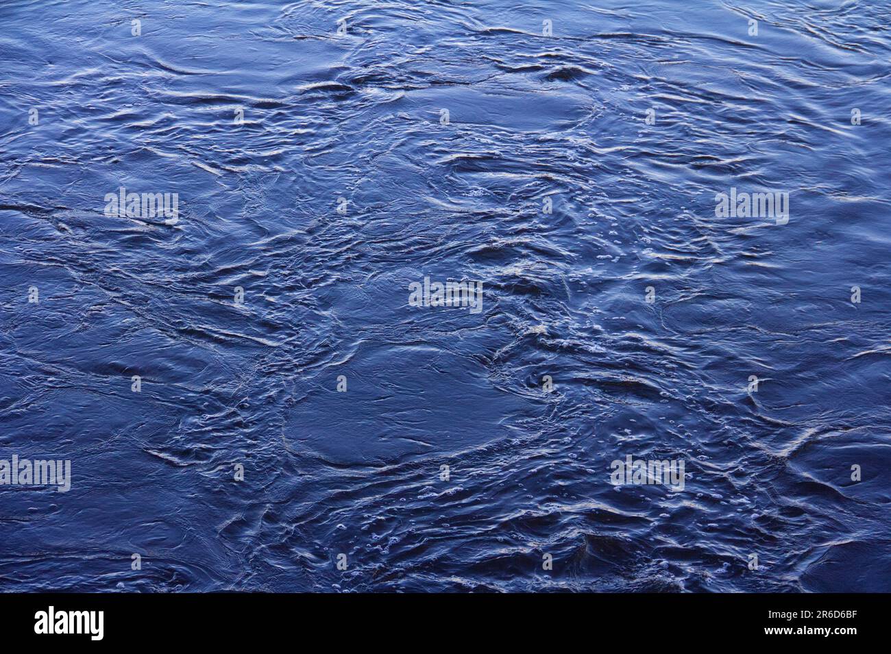 Surface d'eau sombre avec ondulation et vagues. Texture abstraite du liquide bleu fluide. Banque D'Images