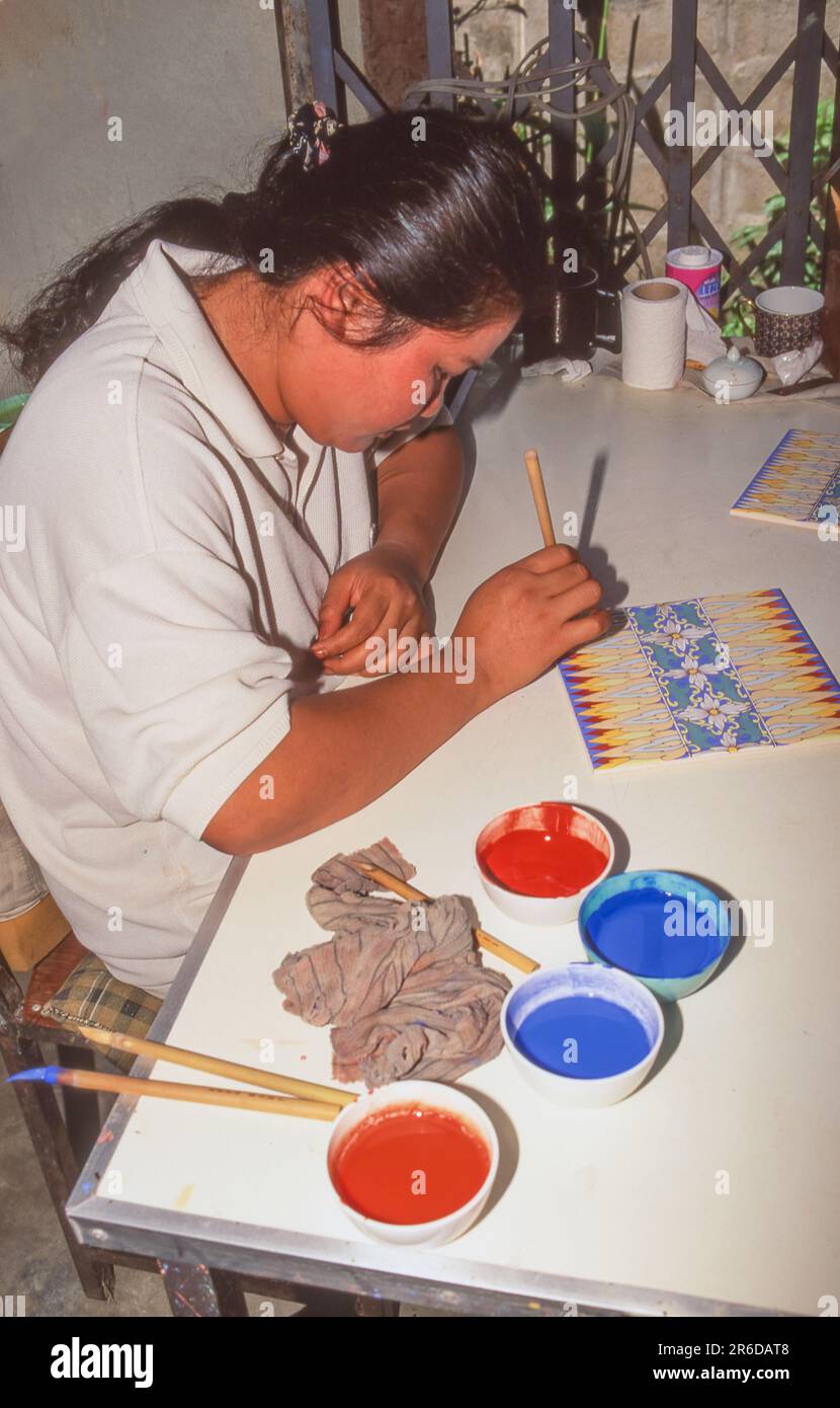 Une artiste féminine peint des carreaux dans une usine de Lampang, la troisième plus grande ville du nord de la Thaïlande. Banque D'Images