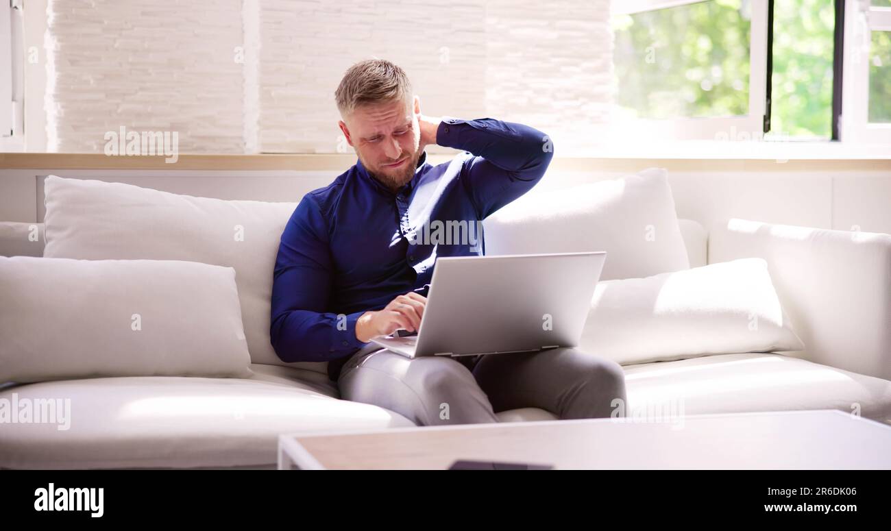 Homme travaillant sur ordinateur portable avec blessure au cou douleur et inflammation Banque D'Images