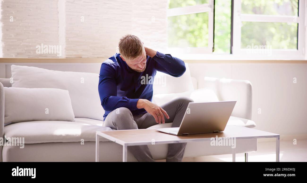 Homme travaillant sur ordinateur portable avec blessure au cou douleur et inflammation Banque D'Images