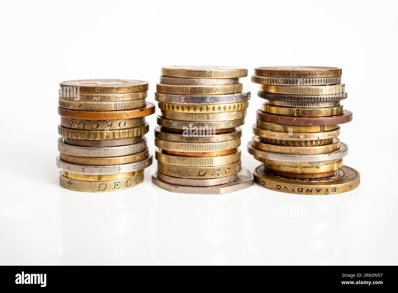 trois piles de pièces de monnaie européennes, isolées sur fond blanc, gros plan flou Banque D'Images