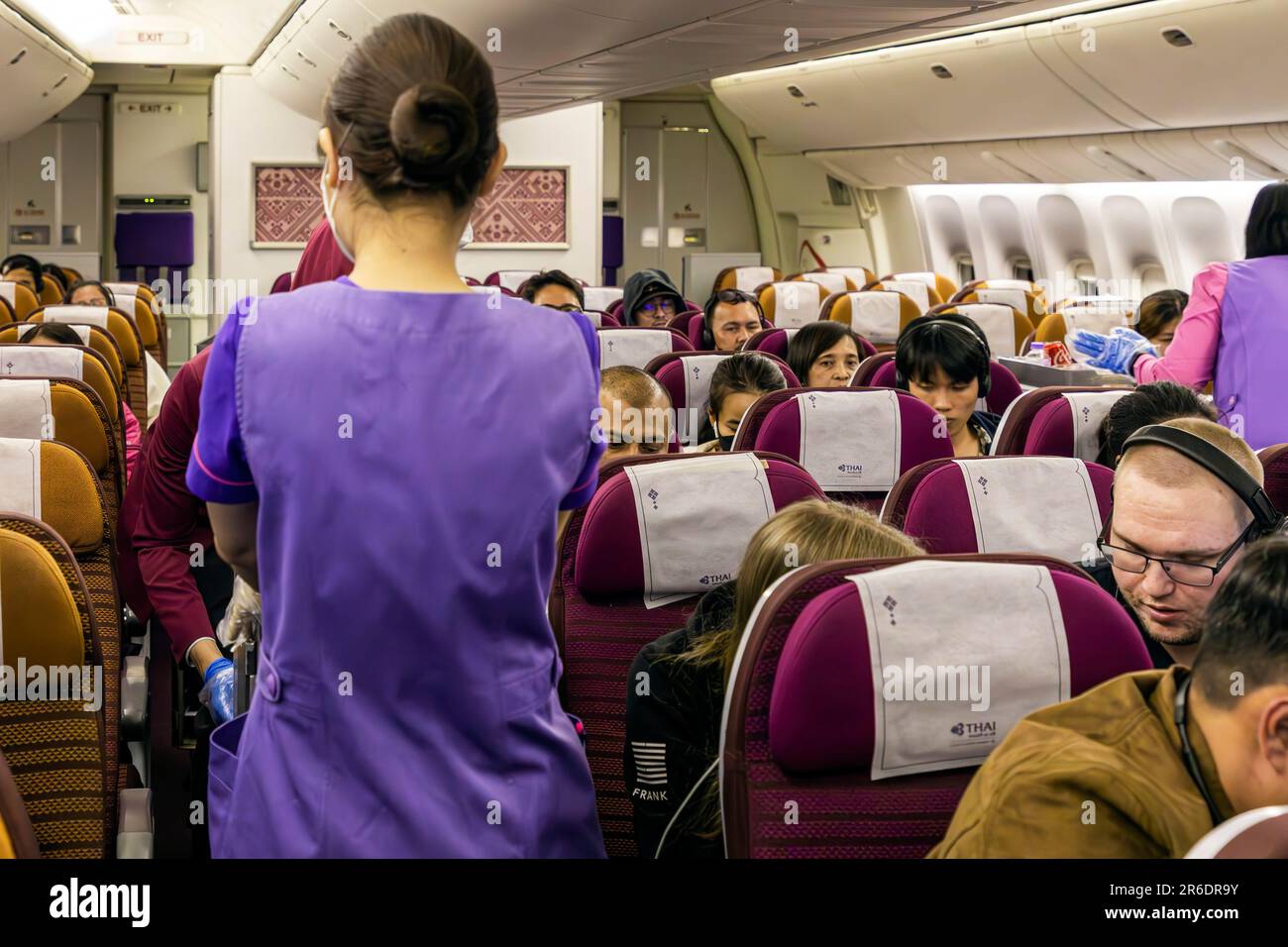 L'équipage de cabine de Thai Airways portant un masque servant les passagers de la section Economy sur le vol international de Manille à Bangkok Banque D'Images