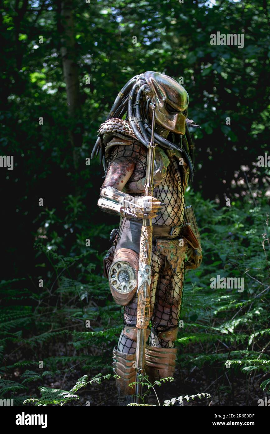 HARROGATE, ROYAUME-UNI - 3 JUIN 2023. Portrait d'un cosplayer habillé comme un étranger Predator en costume réaliste en plein air dans un environnement boisé Banque D'Images
