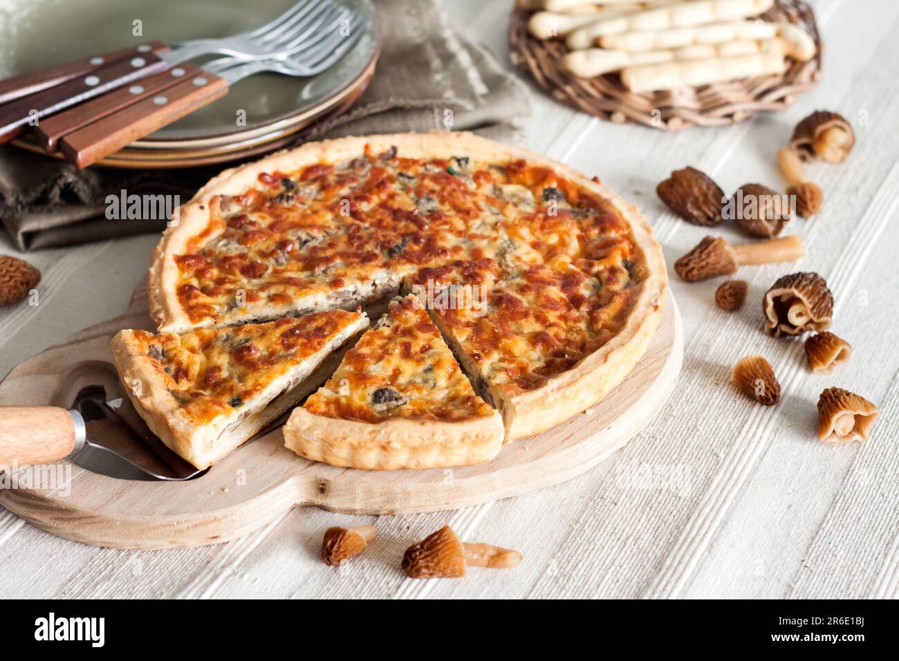 Quiche - tarte ouverte aux morilles, oignons et mozzarella sur planche à découper en bois Banque D'Images