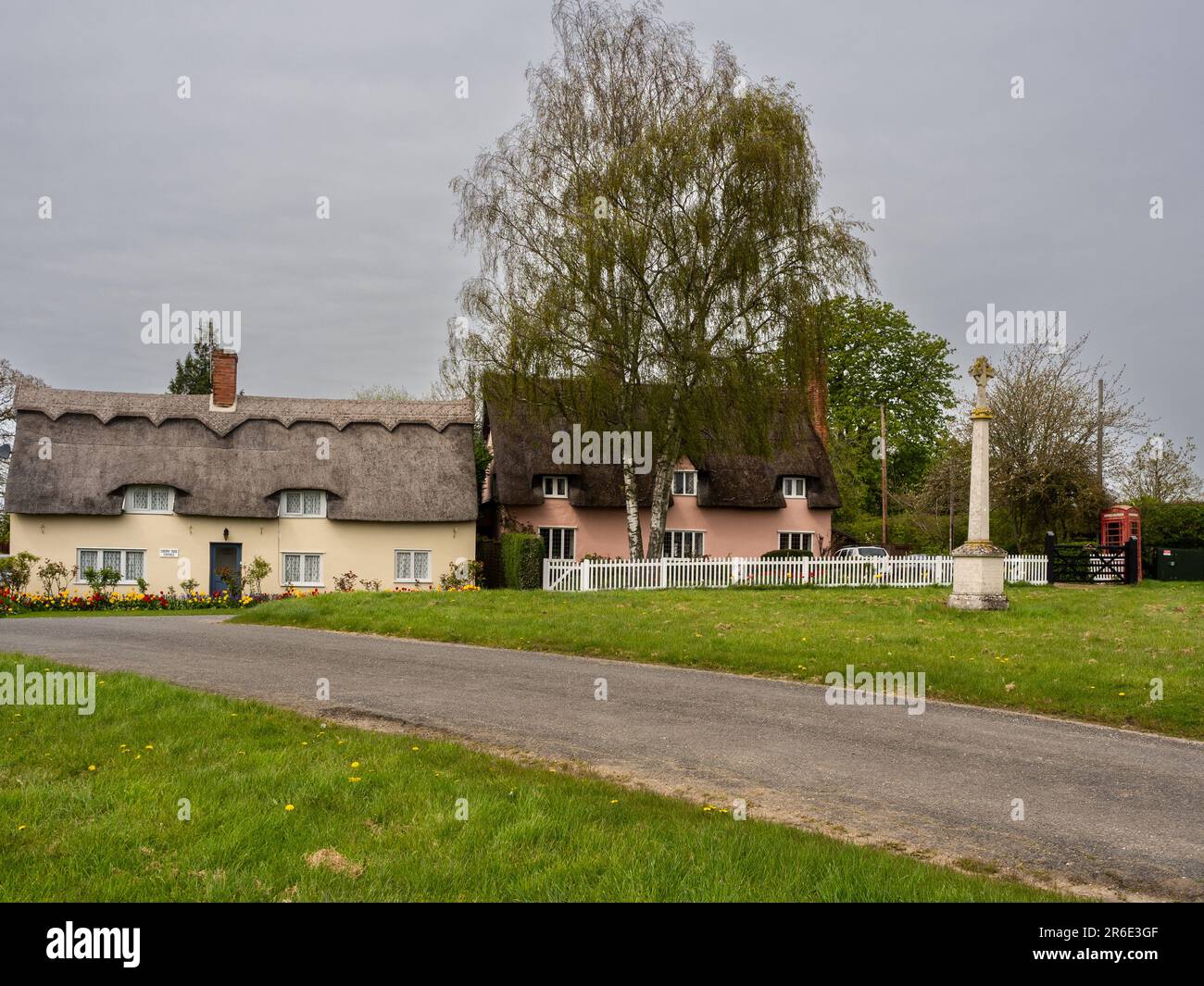 Village vert avec mémorial de guerre et maisons de chaume, Denston, Suffolk, Royaume-Uni Banque D'Images