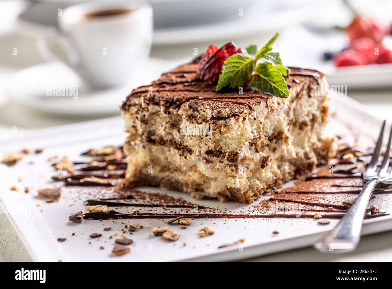Gâteau traditionnel italien tiramisu, servi sur une assiette décorative avec un espresso. Banque D'Images