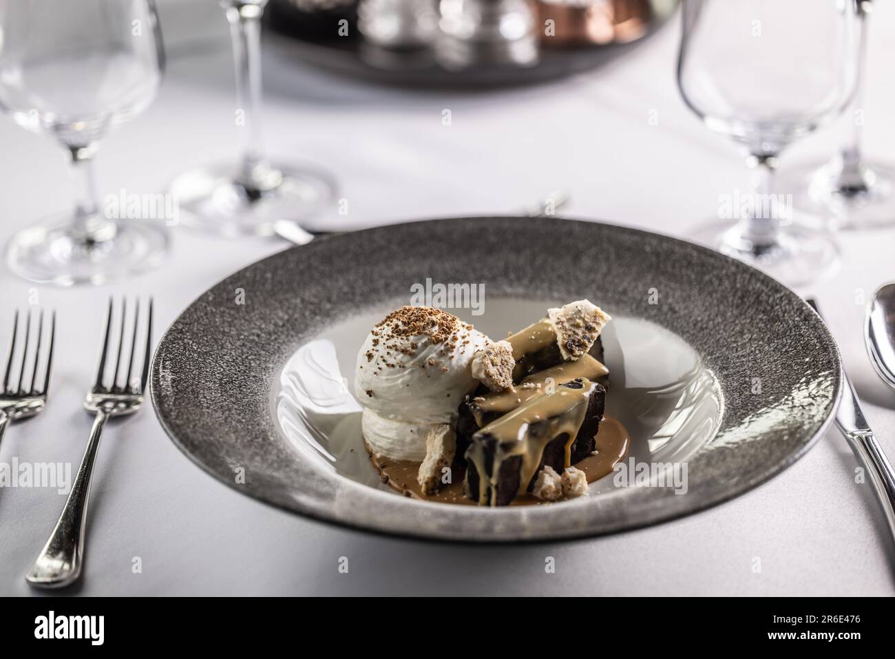 Brownies au chocolat au caramel et à la crème fouettée servies dans une assiette. Banque D'Images