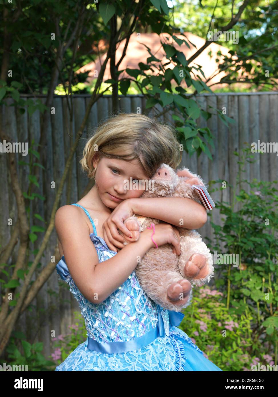 une fille en tutu tient un cochon farci Banque D'Images
