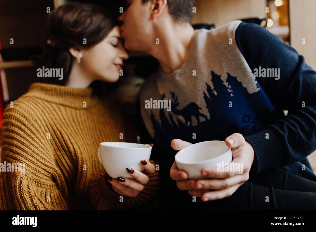 le couple se serre dans ses bras en étant assis dans la cuisine au milieu de noël Banque D'Images