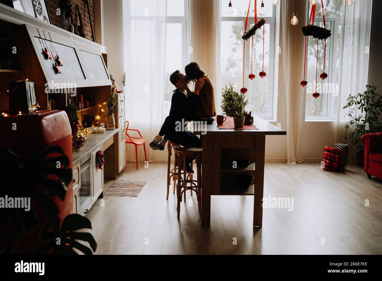 jeune couple embrasse dans la cuisine avant noël Banque D'Images