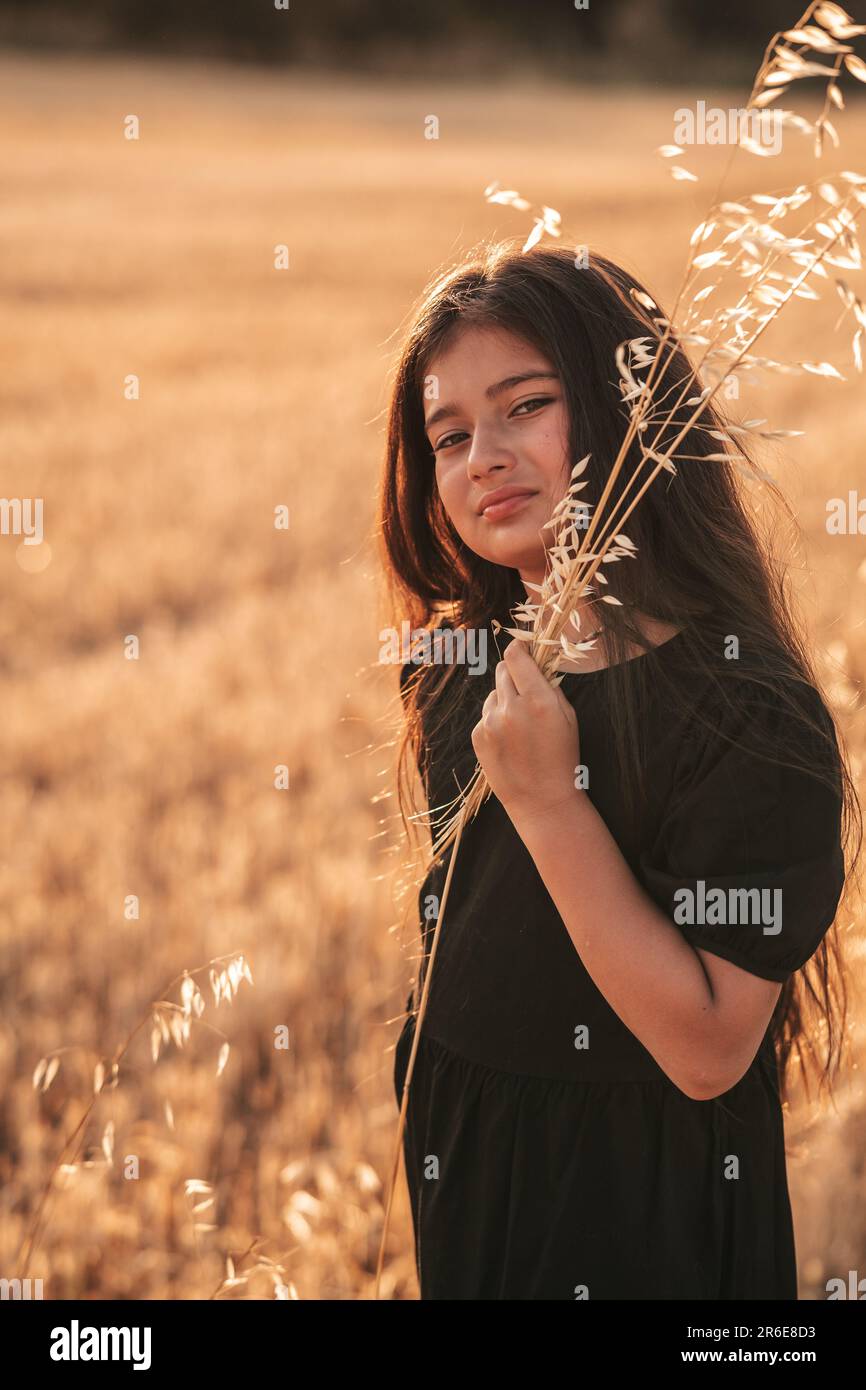 Adolescente en robe noire, asiatique, nature, champ de blé Banque D'Images