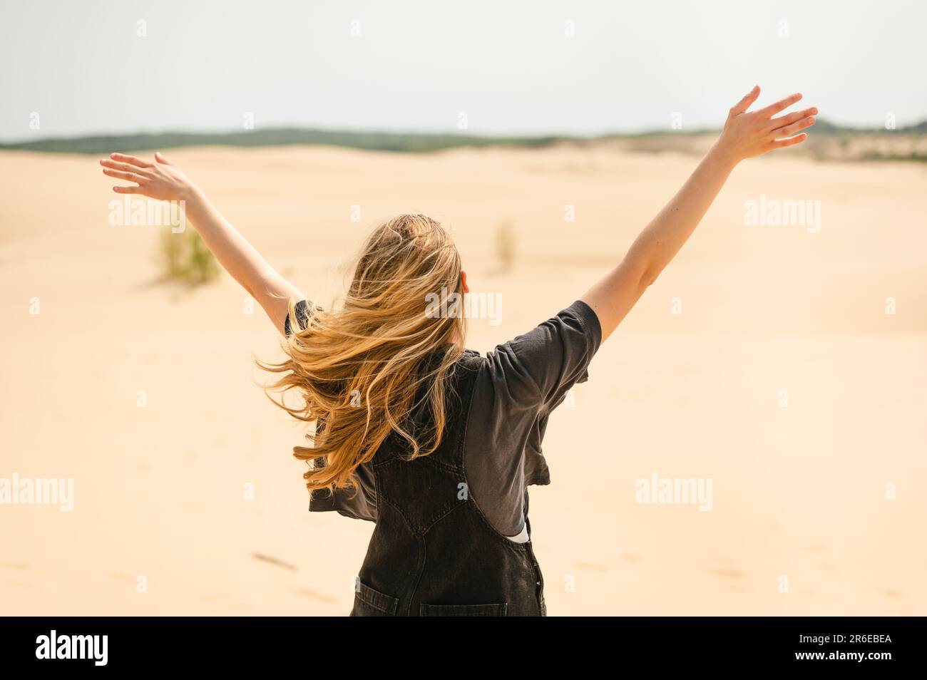 Vue arrière d'une femme aux bras dépassant les dunes de sable du Michigan Banque D'Images