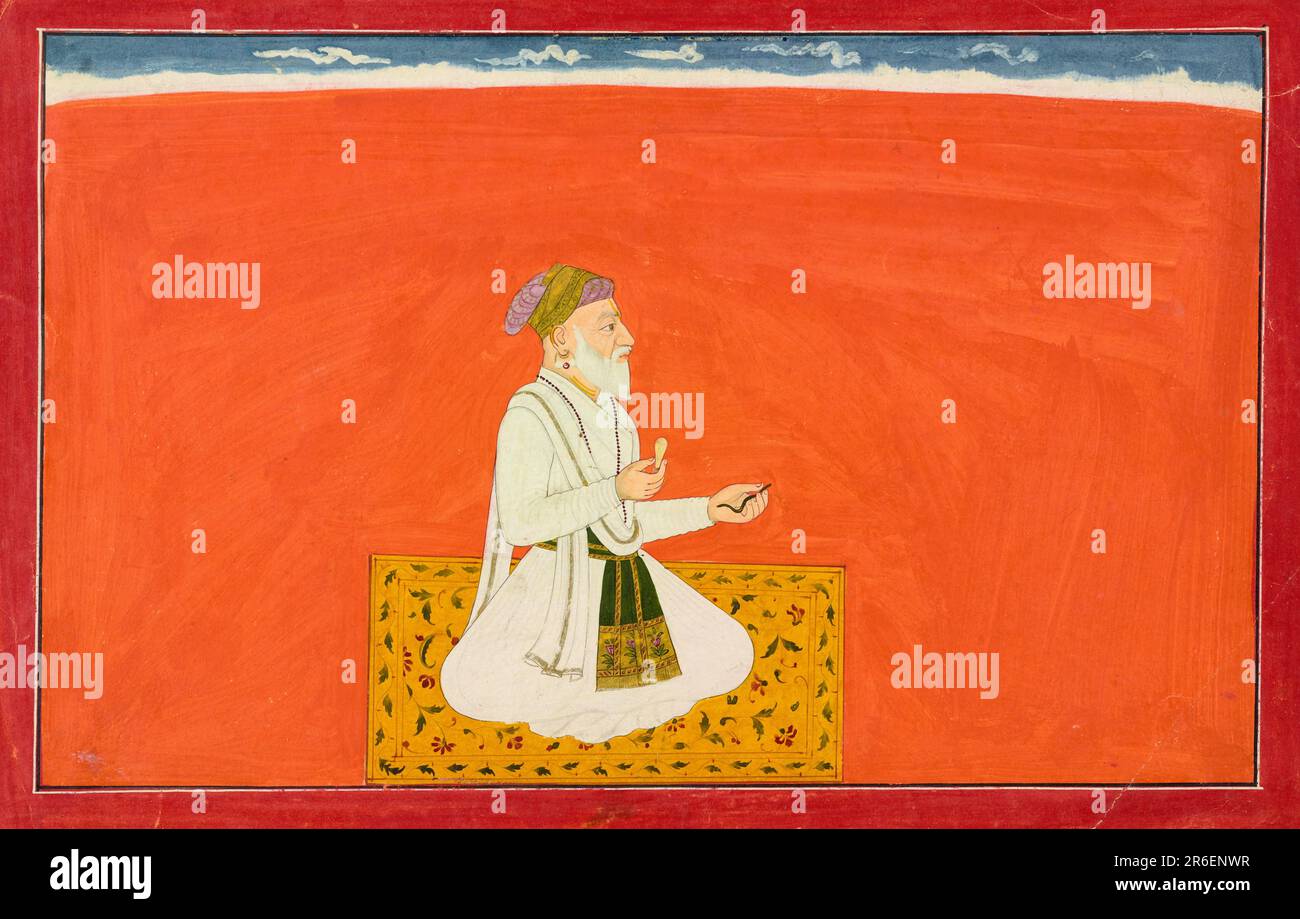 Habillé à la manière d'un noble à la cour de Shah Jahan, le sage divin Dhanvantari porte un jama blanc et une patka bordée d'or (sash) ornée d'un grand motif de fleur. Sa barbe est blanche, son visage ridé avec l'âge, et il porte une marque Vaishnava tilak sur son front. Il est assis sur un tapis jaune décoré de feuilles gris-vert et de fleurs bordeaux. Une bande étroite de ciel à rayures nuagées borde le sol orange brillant. Il détient deux objets qui peuvent être associés à la médecine. Aquarelle opaque et or sur papier. Origine: Guler, État de l'Himachal Pradesh, Inde. Date : env. 1735-1740. UM Banque D'Images