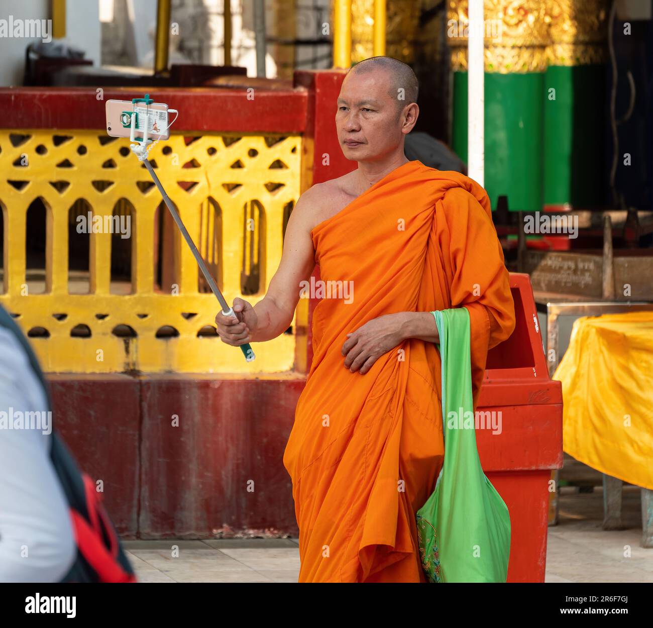Moine bouddhiste prenant un selfie à la Pagode Shwedagon, le monument le plus célèbre de Yangon, au Myanmar. Banque D'Images