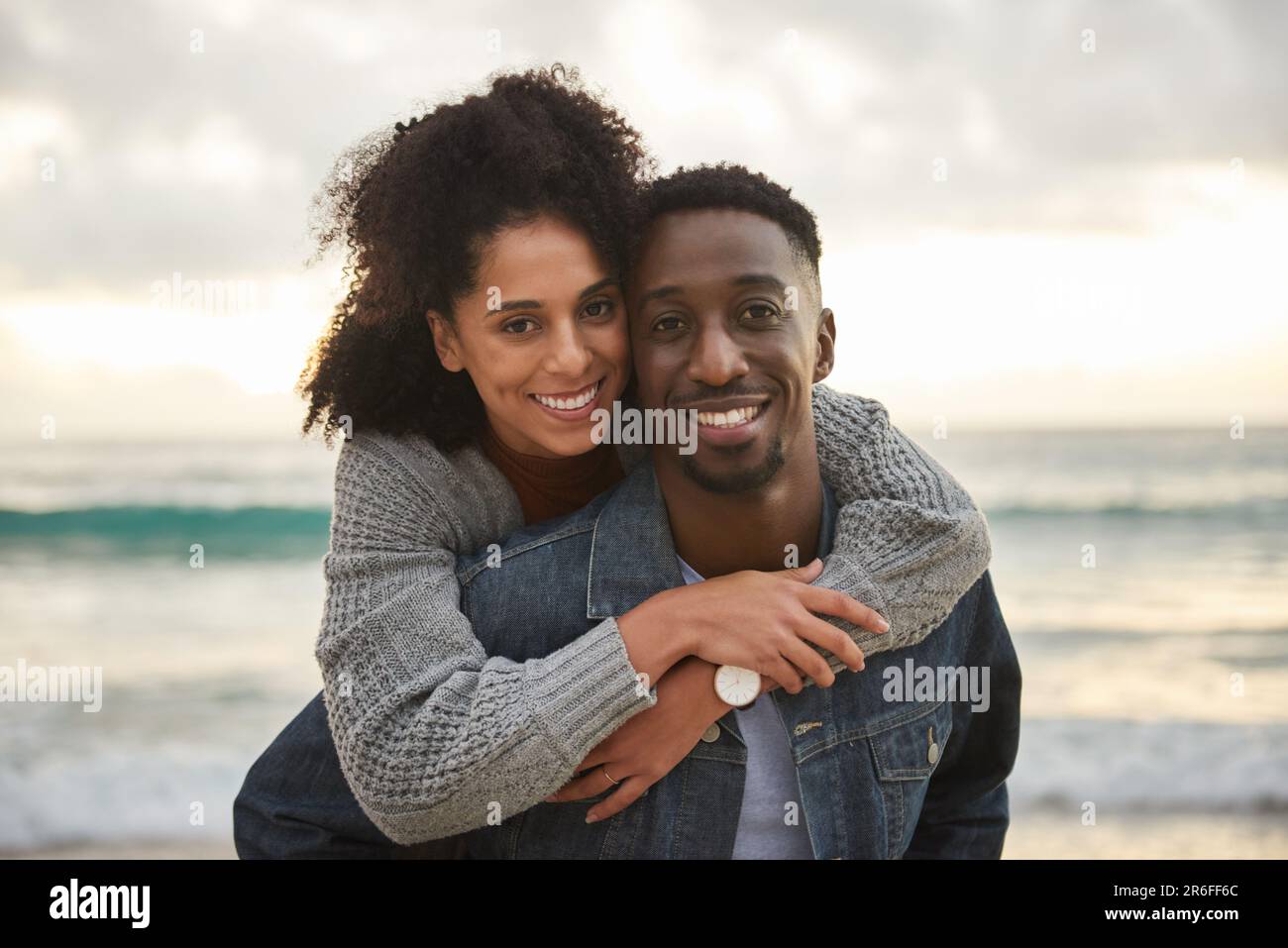 Jeune couple multiethnique souriant s'amuser à la plage Banque D'Images