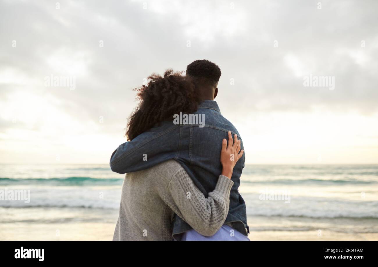 Un couple multiethnique aimant qui regarde l'océan depuis une plage Banque D'Images