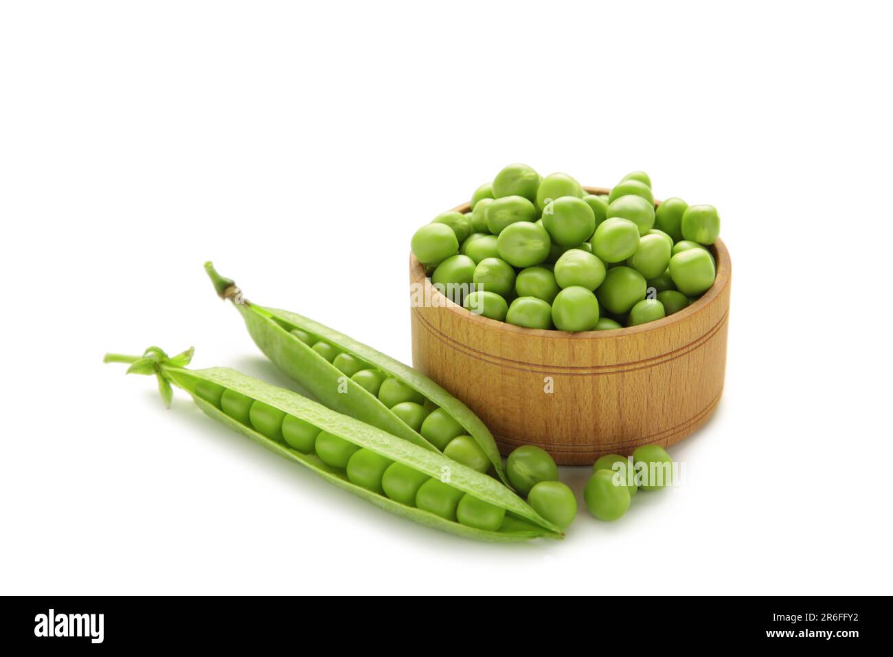 Petits pois verts frais dans un bol isolé sur fond blanc. Vue de dessus Banque D'Images