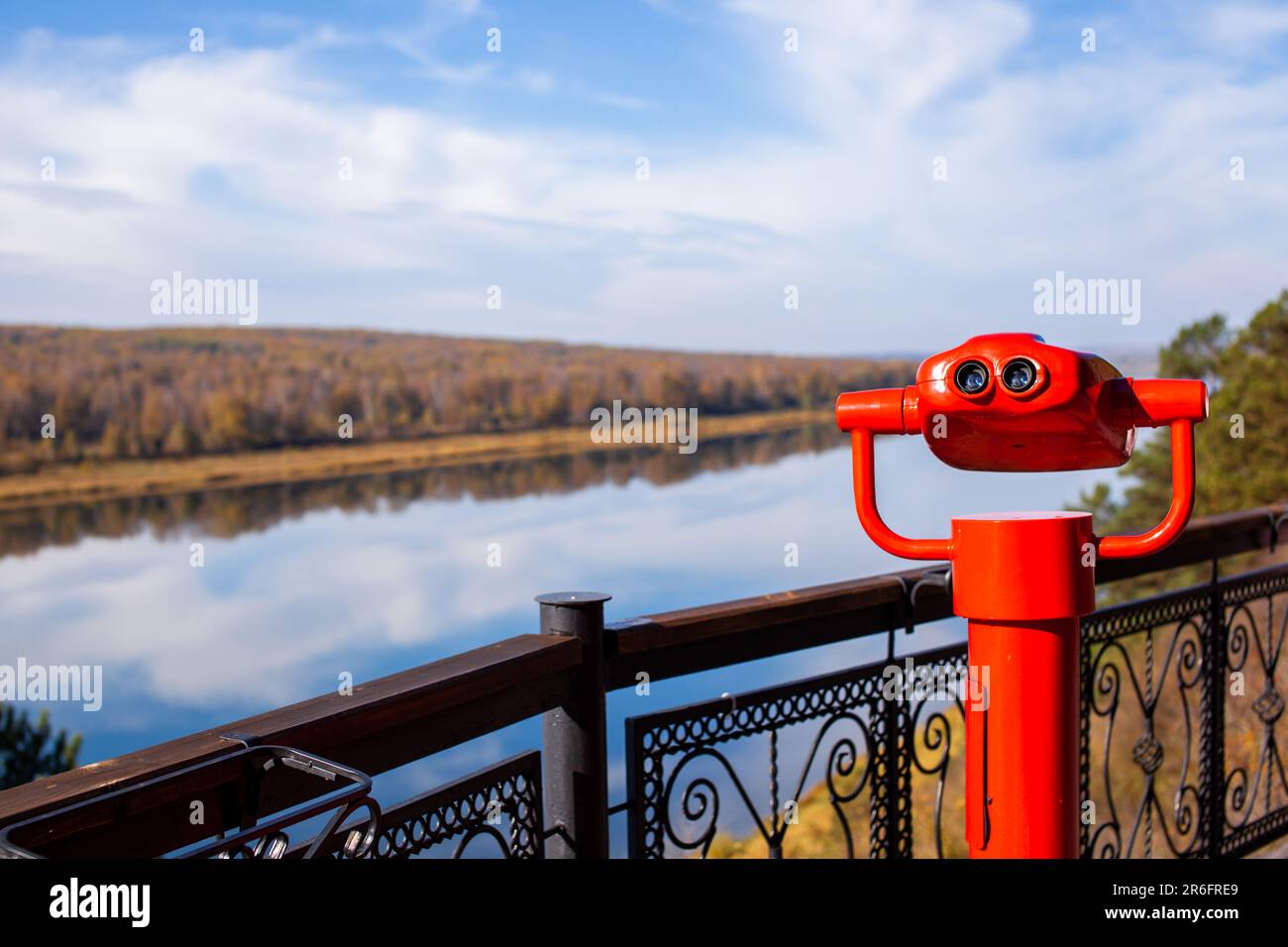 Jumelles fixes publiques sur les rives de la rivière en été ou en automne pour observer la nature, jumelles en métal rouge à pièces. Banque D'Images