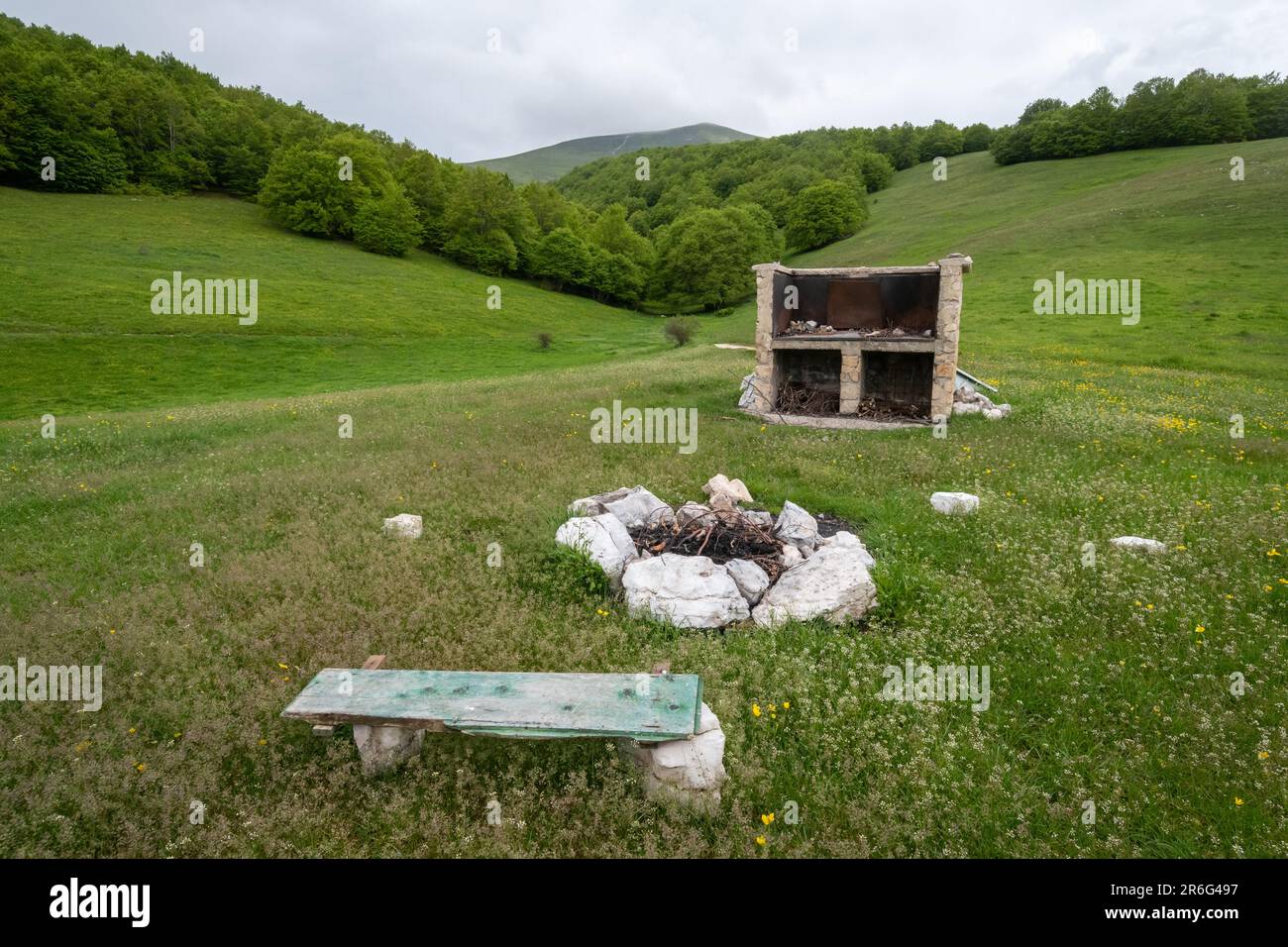 Installations de base dans un camping sauvage, y compris le feu pour la cuisine et un banc en bois de fortune, Ombrie, Italie, Europe Banque D'Images