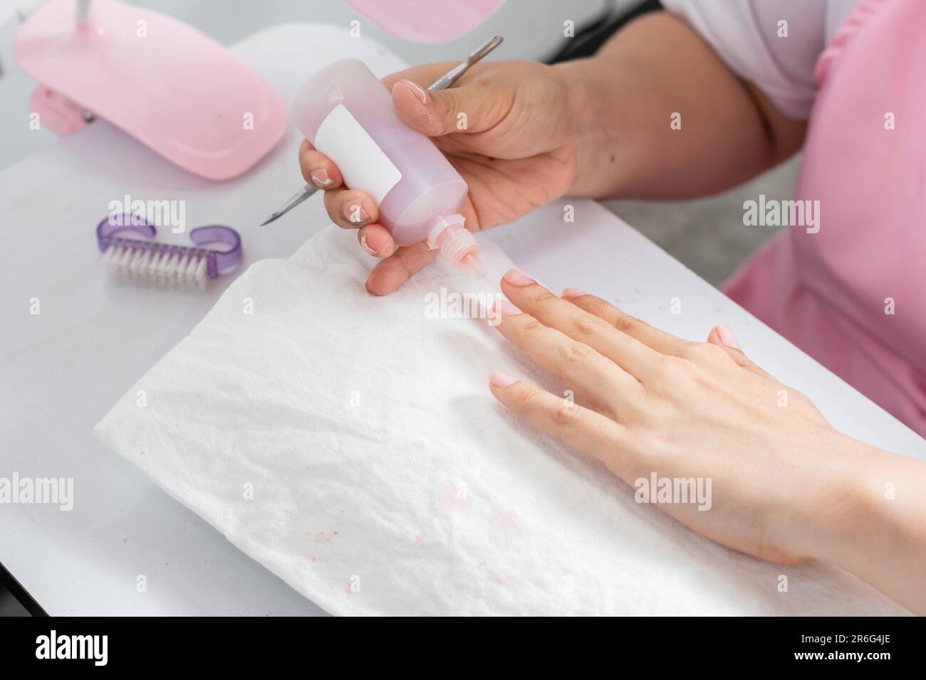 gros plan des mains d'une jeune femme appliquant du dissolvant liquide pour vernis à ongles sur ses ongles Banque D'Images