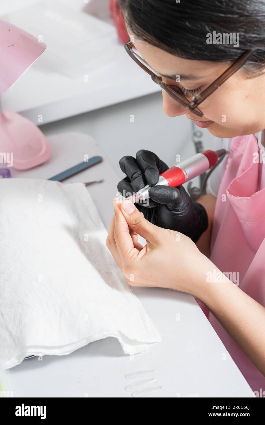 gros plan d'une jeune femme à polir le faux ongle qu'elle utilisera pour la manucure à pression Banque D'Images