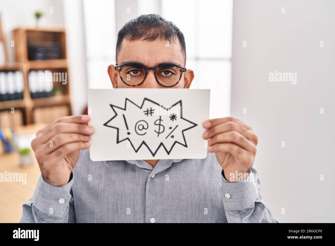 Homme du Moyen-Orient avec la barbe tenant bannière avec des mots jurons sceptique et nerveux, frowning bouleversé à cause du problème. personne négative. Banque D'Images